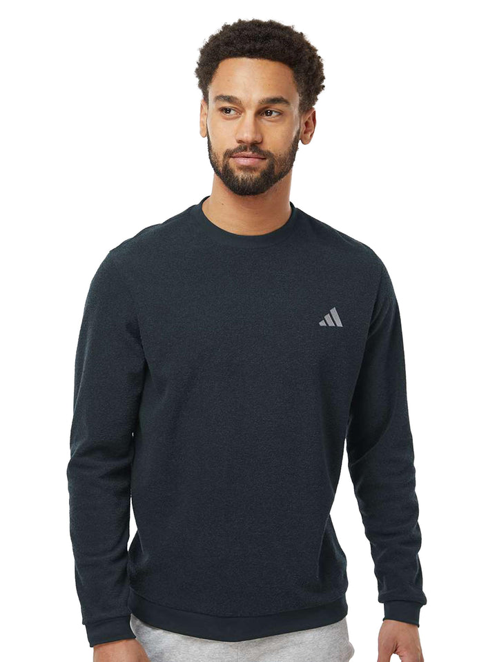 Black Adidas crewneck sweatshirt with a subtle embroidered logo on the chest. A stylish and comfortable option for casual wear.
