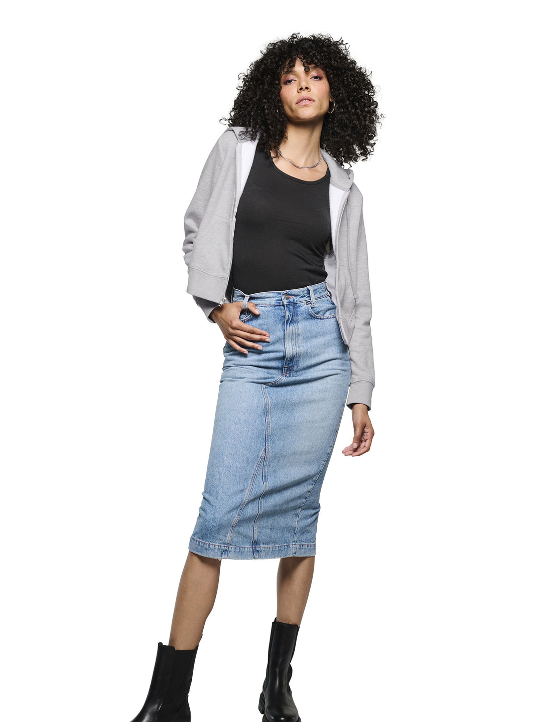 Custom District Women’s Zip-Up Hoodie in light gray, paired with a denim skirt and black boots. A trendy cropped hoodie ready for personalization.