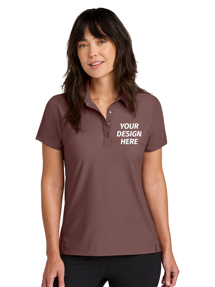 Custom OGIO Women’s Envision Polo in brown with 'Your Design Here' text, ideal for personalized embroidery or printing with no minimums.