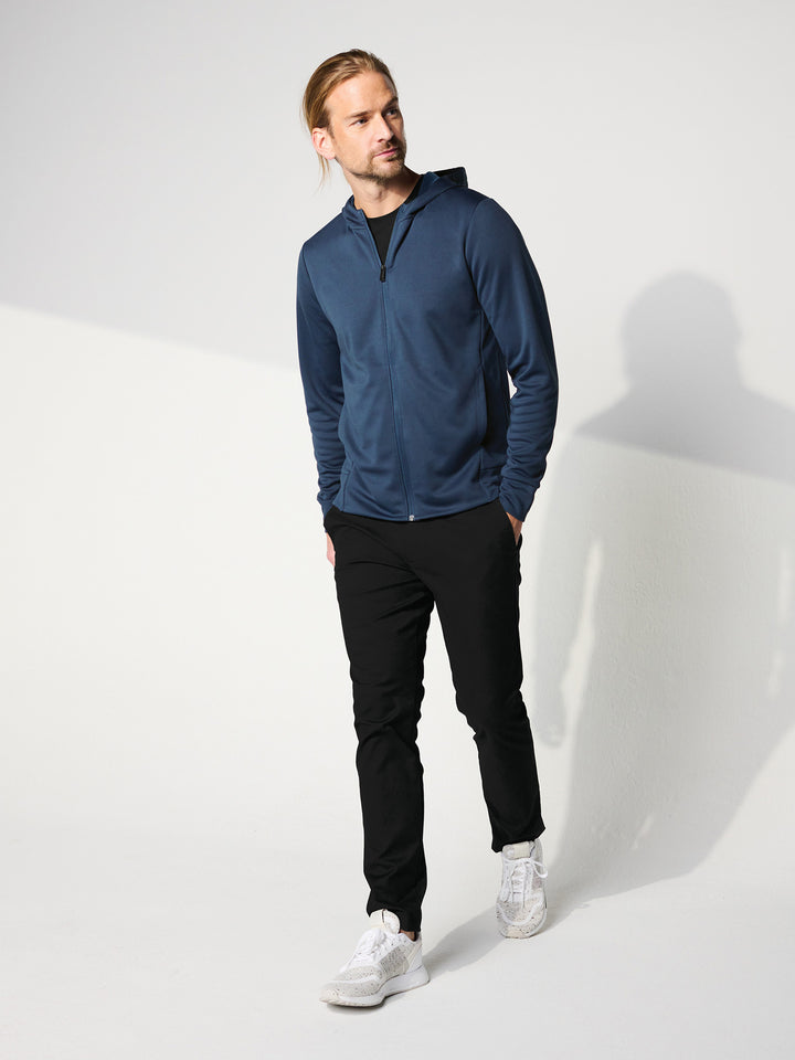 Casual look featuring the Custom Mercer and Mettle Double Knit Zip Hoodie in navy blue, styled with black pants and white sneakers. Perfect for everyday wear.