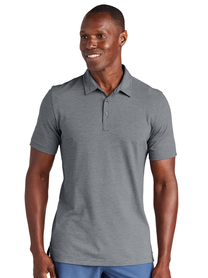 TravisMathew Sunnyvale Polo in light gray, offering a modern fit and moisture-wicking performance. Add your custom logo with no minimum order requirements.
