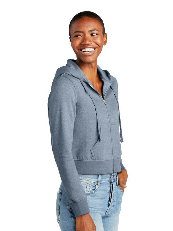 Side view of a Custom District Women’s Zip-Up Hoodie in blue, showcasing its cropped design and soft fleece fabric. Ideal for personalized embroidery or printing.