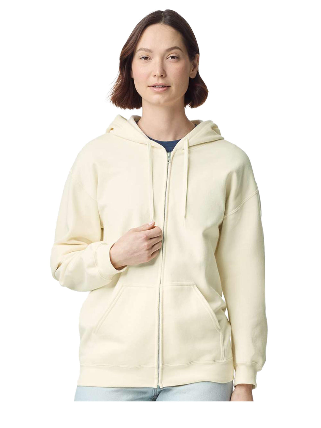 Female model wearing a Gildan Softstyle Full Zip Hooded Sweatshirt in cream, showcasing its unisex fit and cozy fabric. Great for casual wear and customization.