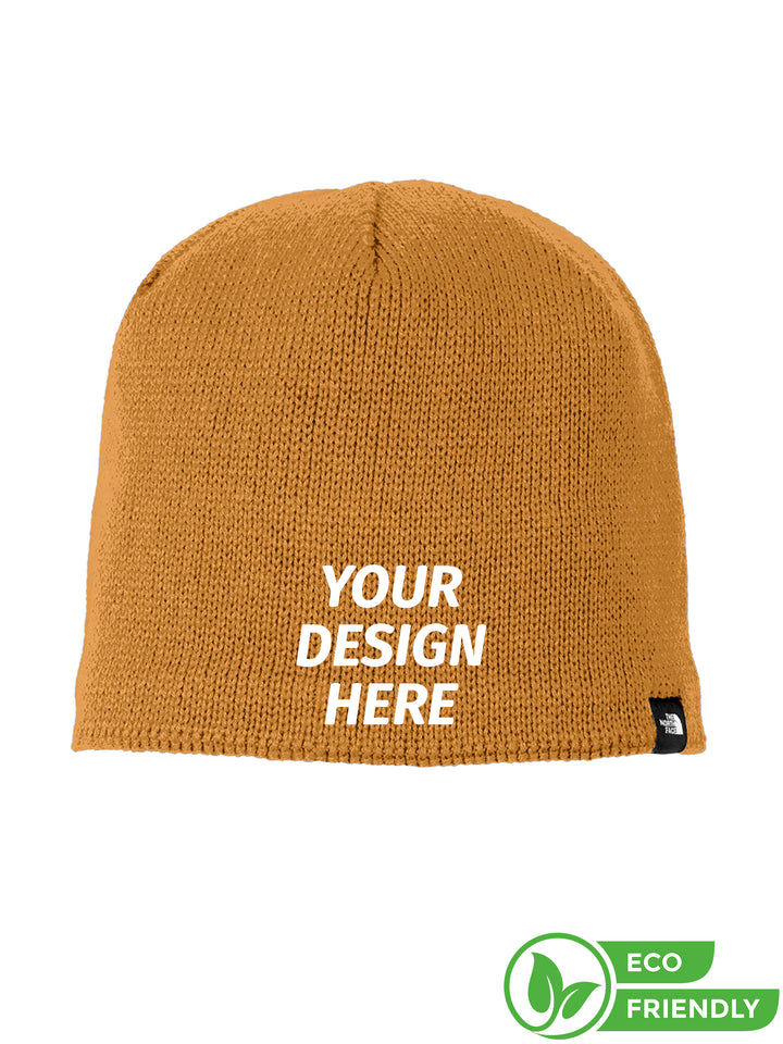 The North Face® Mountain Beanie in mustard yellow with customizable embroidery. Eco-friendly design with a soft knit fabric for warmth and comfort.