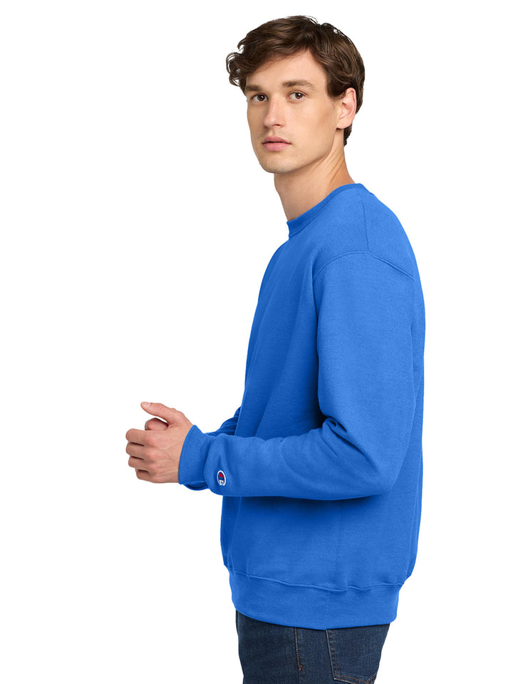 Side view of the Custom Champion Powerblend Crewneck S6000 in royal blue. Features the Champion logo on the sleeve and a relaxed fit.